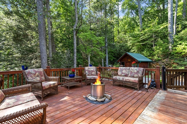 wooden deck with an outdoor living space with a fire pit