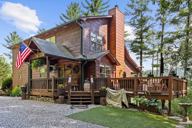 view of front facade with a deck and a front lawn