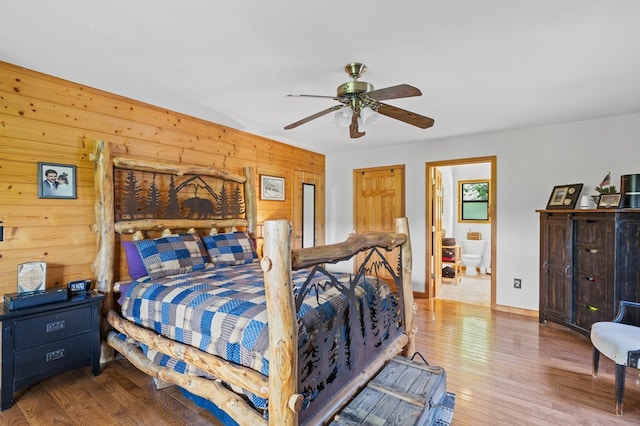 bedroom featuring wood-type flooring, ceiling fan, and wood walls