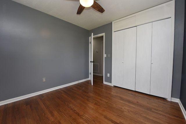 unfurnished bedroom featuring ceiling fan, dark hardwood / wood-style flooring, and a closet