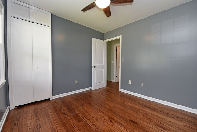 unfurnished bedroom featuring ceiling fan, dark hardwood / wood-style flooring, and a closet