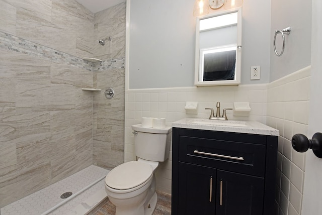 bathroom featuring tile walls, vanity, toilet, and tiled shower