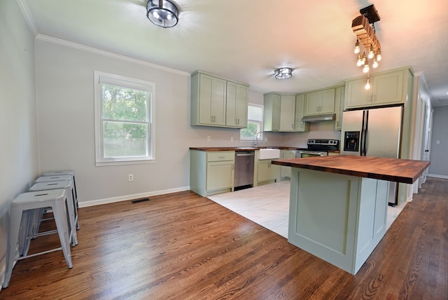 kitchen featuring wood counters, appliances with stainless steel finishes, light hardwood / wood-style flooring, and green cabinetry