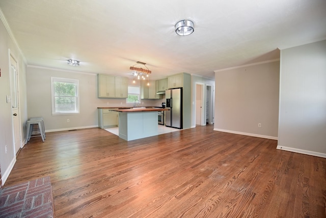 kitchen with stainless steel fridge with ice dispenser, light hardwood / wood-style flooring, ornamental molding, and a center island