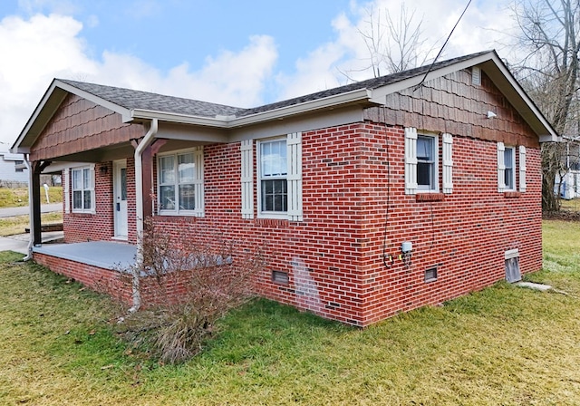 view of side of home featuring a patio and a yard