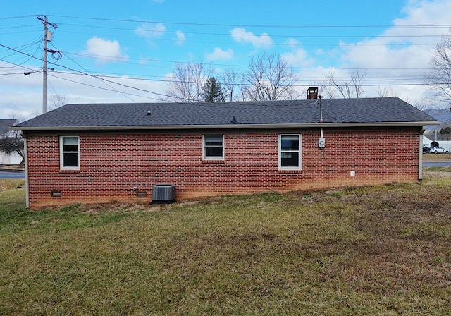 rear view of property with a yard and central AC