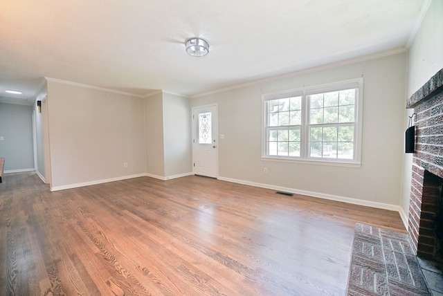 unfurnished living room with hardwood / wood-style floors, a fireplace, and ornamental molding