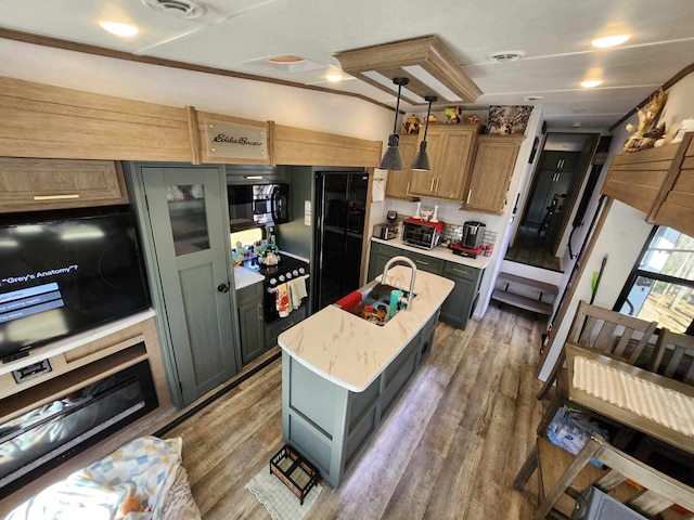 kitchen with light wood finished floors, visible vents, a kitchen island, hanging light fixtures, and light countertops