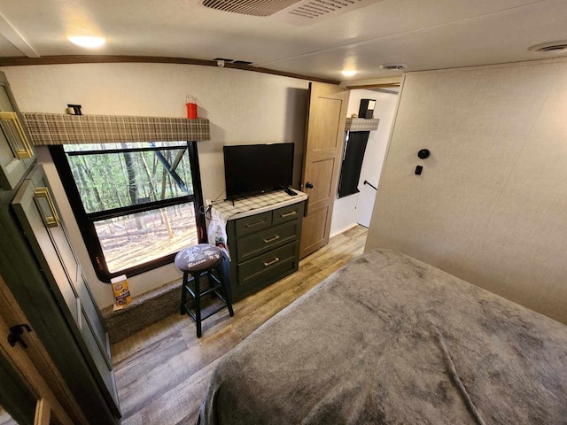 bedroom featuring ornamental molding, visible vents, and light wood finished floors