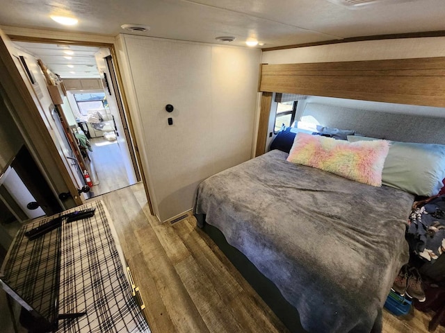 bedroom featuring multiple windows, visible vents, and wood finished floors