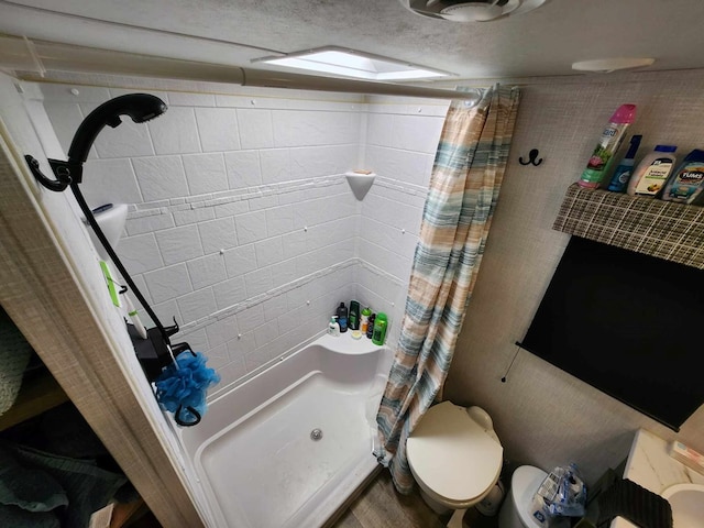 full bath with toilet and a shower with shower curtain