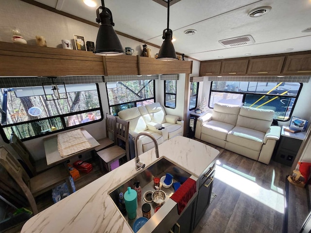 living area with visible vents and wood finished floors