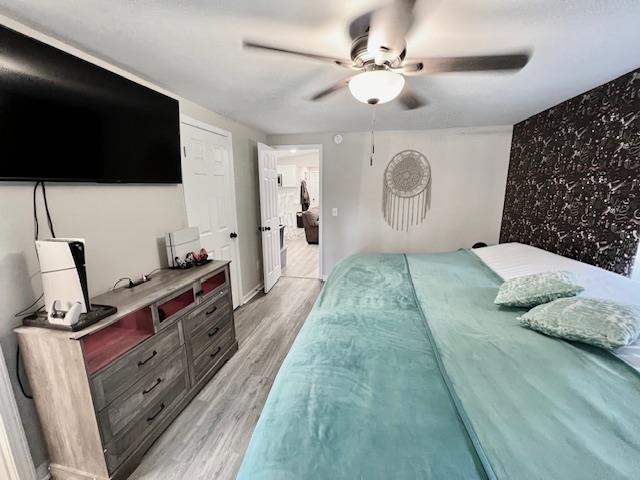 bedroom with ceiling fan and light hardwood / wood-style floors