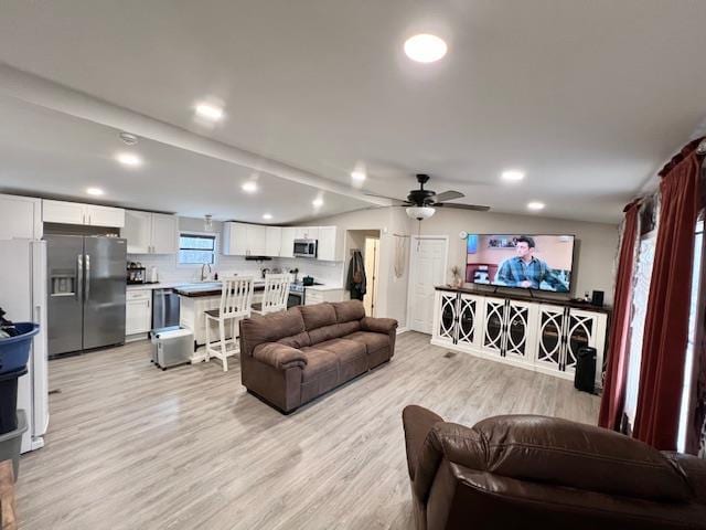 living room with light hardwood / wood-style flooring and ceiling fan