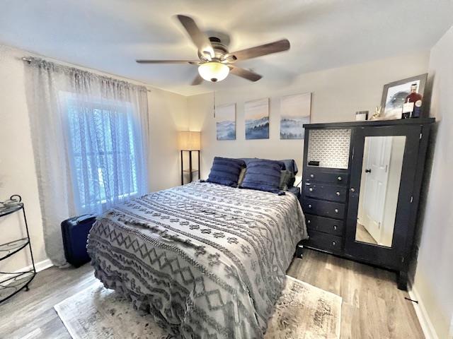 bedroom with light hardwood / wood-style flooring and ceiling fan