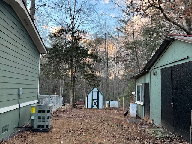 view of yard with central air condition unit and a storage shed