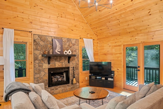 living room featuring a wealth of natural light, light wood-type flooring, and high vaulted ceiling