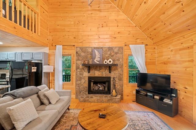 living room with wood walls, wood ceiling, high vaulted ceiling, and light hardwood / wood-style flooring