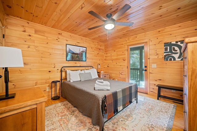 bedroom with wooden ceiling, access to outside, wooden walls, ceiling fan, and light hardwood / wood-style floors