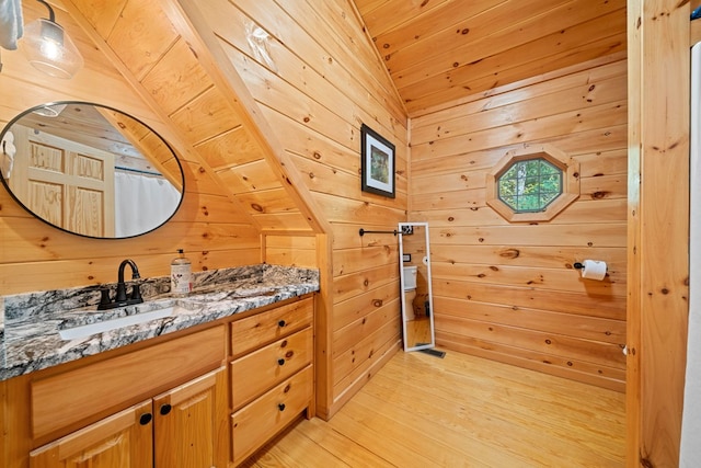 bathroom with vanity, wood walls, lofted ceiling, wooden ceiling, and hardwood / wood-style flooring