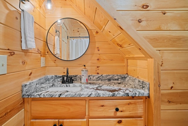 bathroom featuring vanity and wood walls