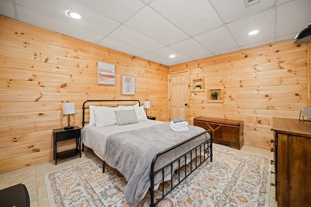 bedroom with a paneled ceiling and wooden walls