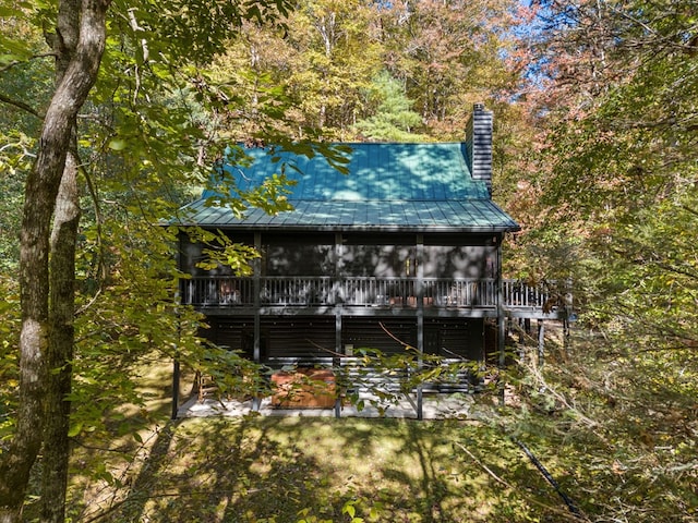 back of property with a sunroom and a deck