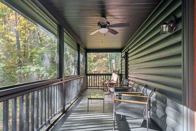 unfurnished sunroom featuring plenty of natural light, wooden ceiling, and ceiling fan