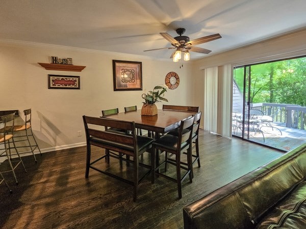 dining room with dark wood-style flooring, a ceiling fan, ornamental molding, and baseboards