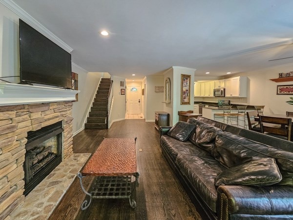 living area with recessed lighting, stairs, baseboards, and wood finished floors