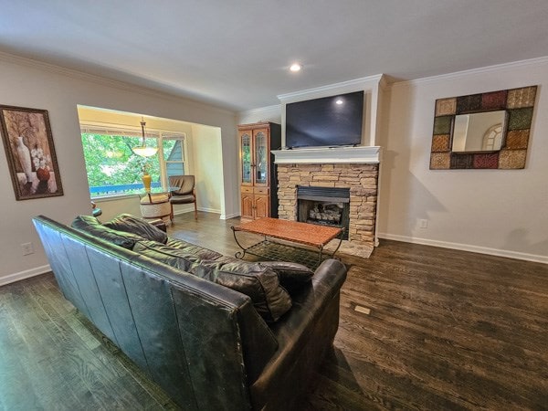 living area featuring a stone fireplace, crown molding, wood finished floors, baseboards, and recessed lighting
