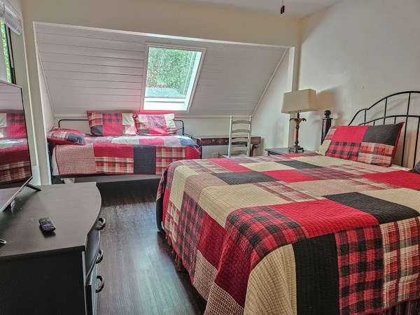 bedroom with wood finished floors and multiple windows