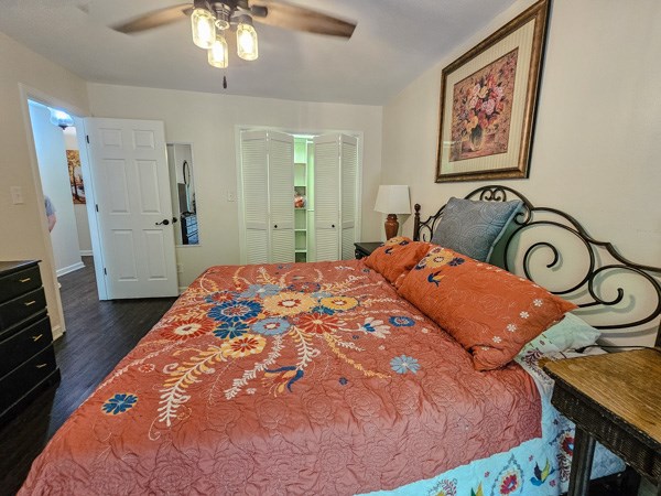 bedroom featuring a closet, a ceiling fan, and dark wood-style floors