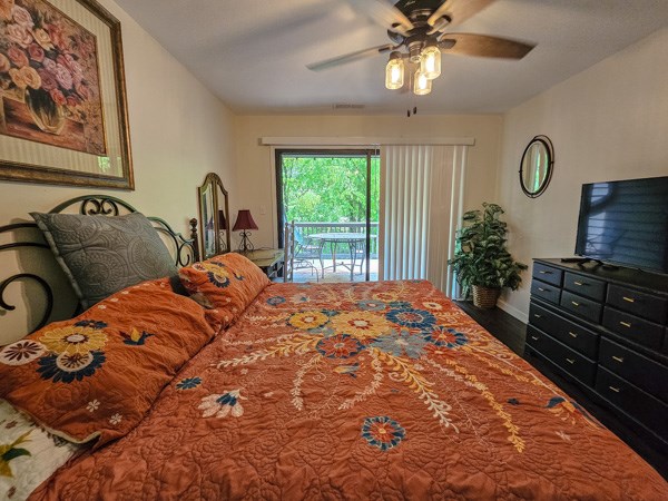 bedroom with baseboards, ceiling fan, wood finished floors, and access to exterior