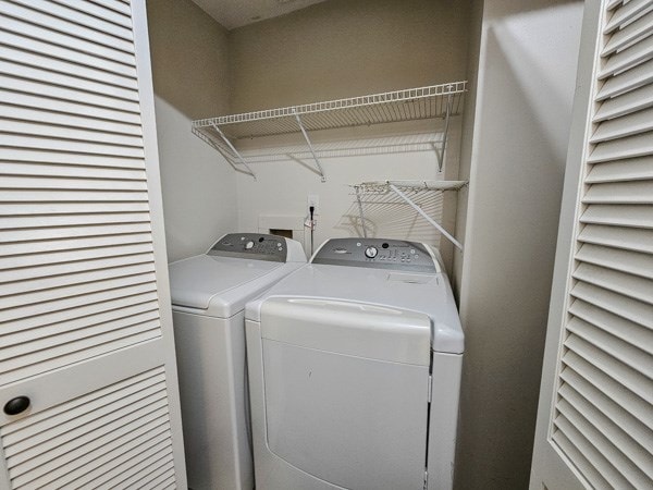 clothes washing area featuring laundry area and washer and clothes dryer