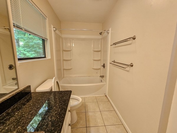 bathroom featuring bathtub / shower combination, vanity, toilet, tile patterned floors, and baseboards