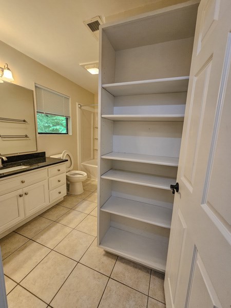 full bath with tile patterned floors, vanity, toilet, and visible vents