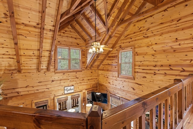 stairs with wood ceiling, wood walls, and vaulted ceiling with beams