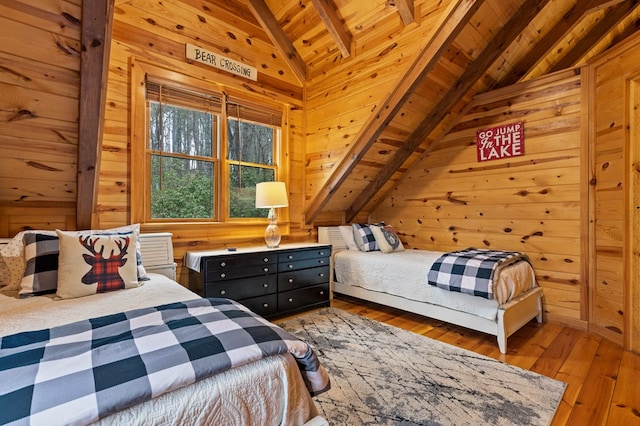 bedroom with wooden walls, wood ceiling, lofted ceiling with beams, and hardwood / wood-style floors