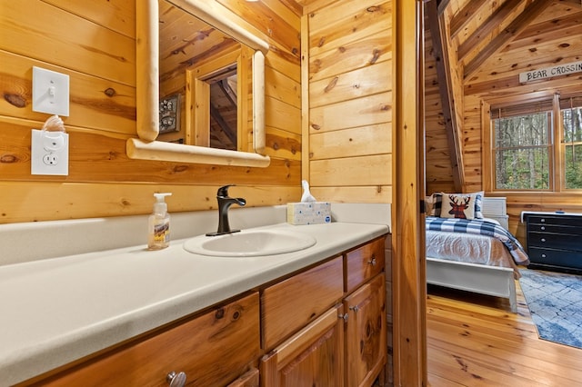 bathroom with wood walls, vanity, and hardwood / wood-style flooring