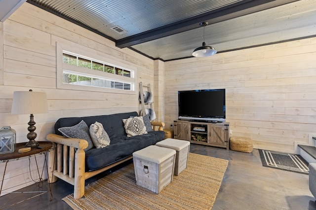 living area featuring beam ceiling, finished concrete floors, and wood walls