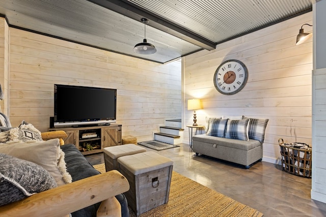 living area featuring finished concrete floors, beamed ceiling, and wooden walls