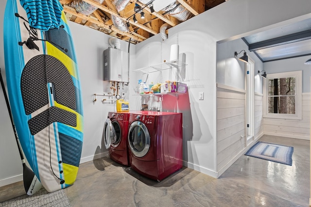 laundry area featuring tankless water heater, baseboards, laundry area, and washer and clothes dryer