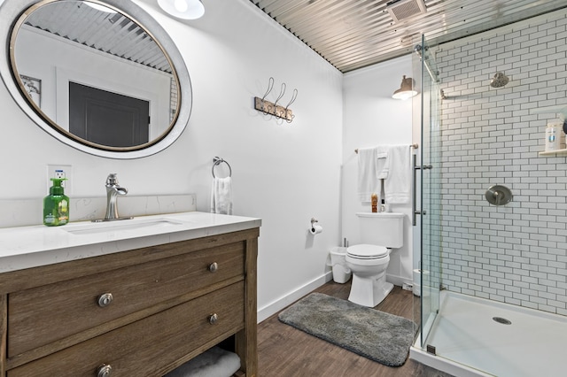 bathroom featuring a shower stall, baseboards, toilet, wood finished floors, and vanity