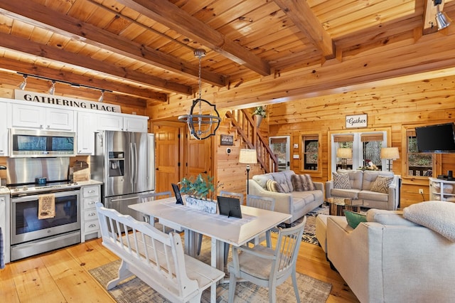 interior space featuring wooden walls, light wood-style flooring, stairway, and wood ceiling