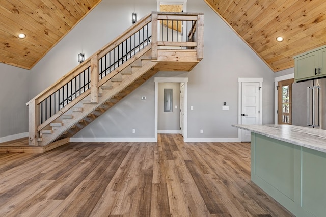 unfurnished living room featuring high vaulted ceiling, wood finished floors, wood ceiling, and baseboards