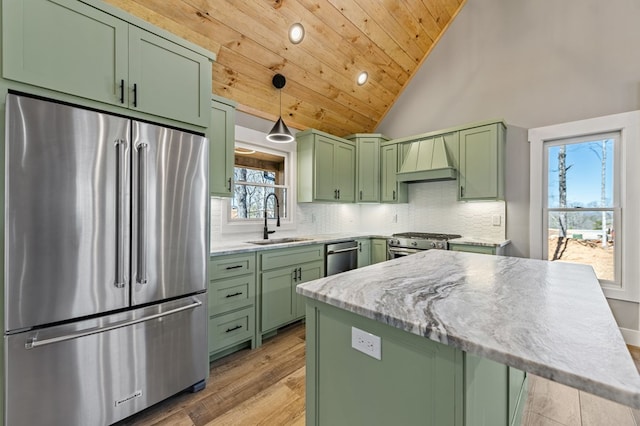 kitchen featuring stainless steel appliances, a sink, green cabinets, custom exhaust hood, and backsplash