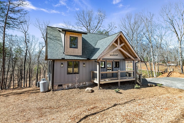 view of front of house featuring driveway, crawl space, a shingled roof, and board and batten siding