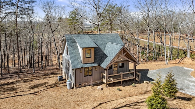 view of front of house with central AC, a shingled roof, driveway, crawl space, and board and batten siding