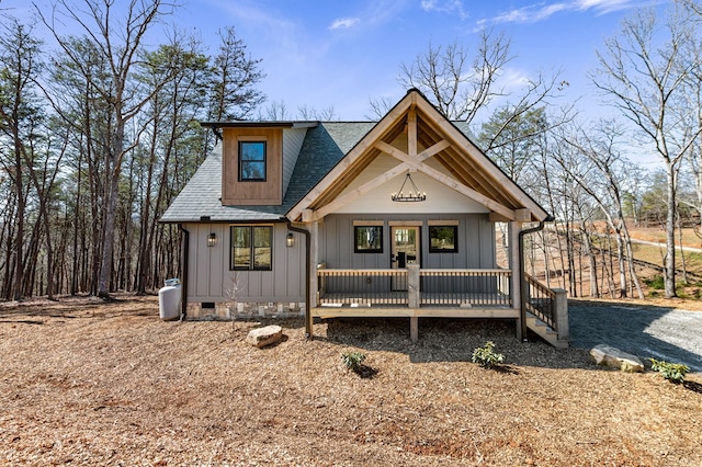 view of front of home featuring roof with shingles, crawl space, board and batten siding, and a wooden deck